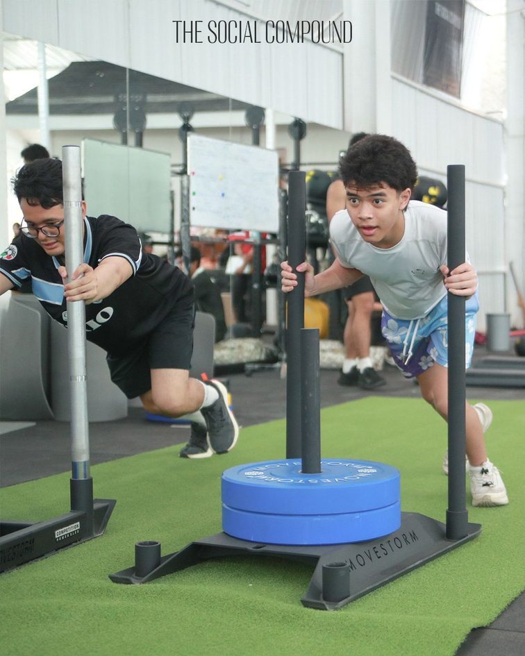 Athletes pushing a training sled in the functional gym